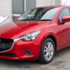 査定を受ける赤いマツダ2の車両確認