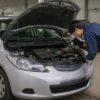 購入前にマツダ2のエンジンルームを点検するメカニック